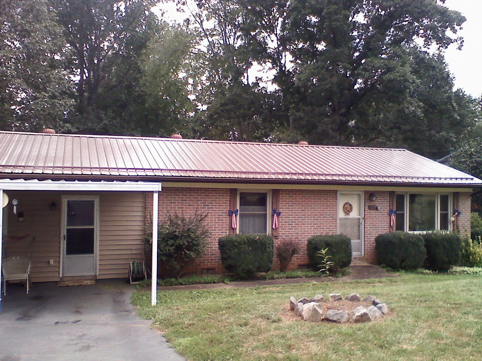 Bronze metal roof and carport on a brick ranch home — Roof Repair work by our crew in Ellsworth